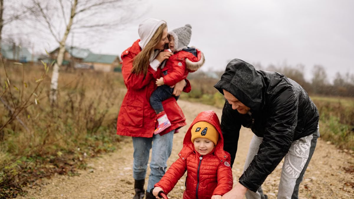 A family enjoying quality time outdoors, walking and playing together in the countryside.